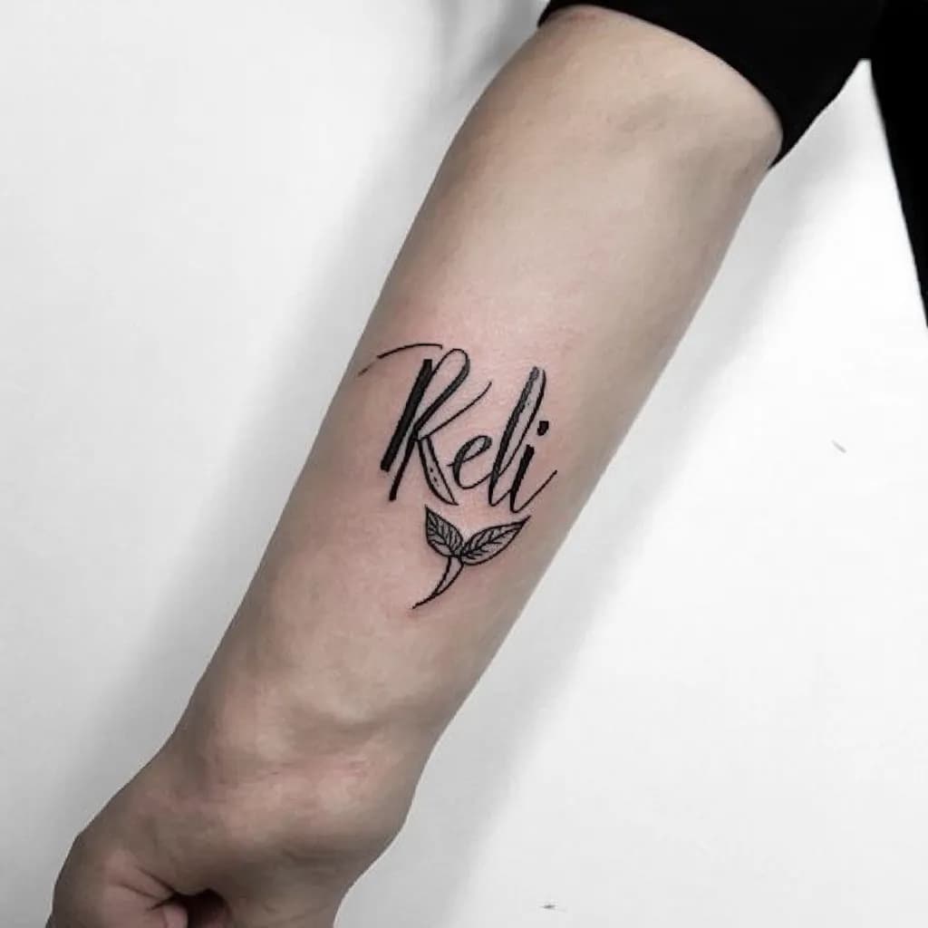 bold cursive 'kelli', bold modern calligraphy with flowing flourishes, thin gray shading, tiny leaf accent, forearm sized